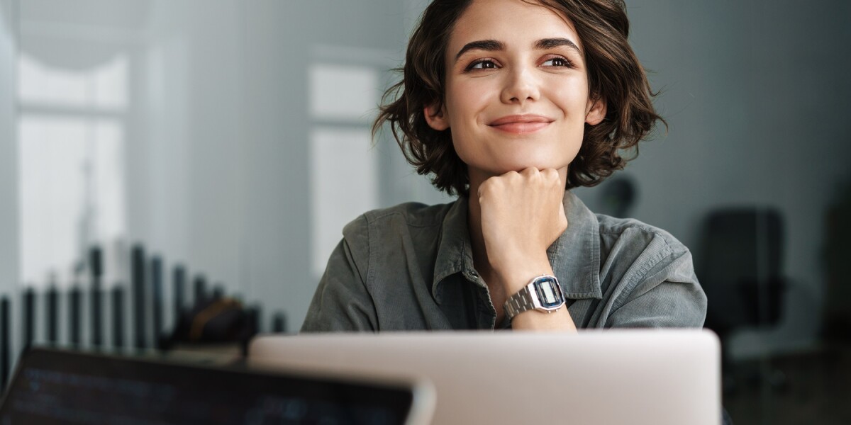 administrative professional sitting at desk and smiling